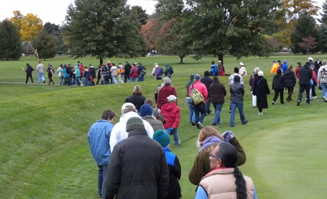 People carefully walking in a procession into the Octagon State Memorial. Image courtesy of Timothy E. Black.