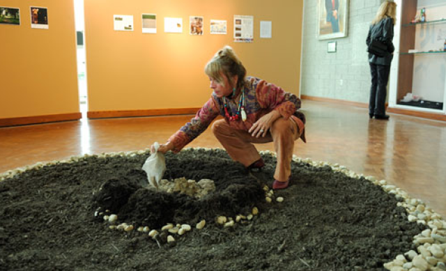 Dr. Christine Ballengee-Morris placing ashes into a central fire exhibit at the Newark Earthworks Day exhibit, 2009. Image courtesy of Timothy E. Black.