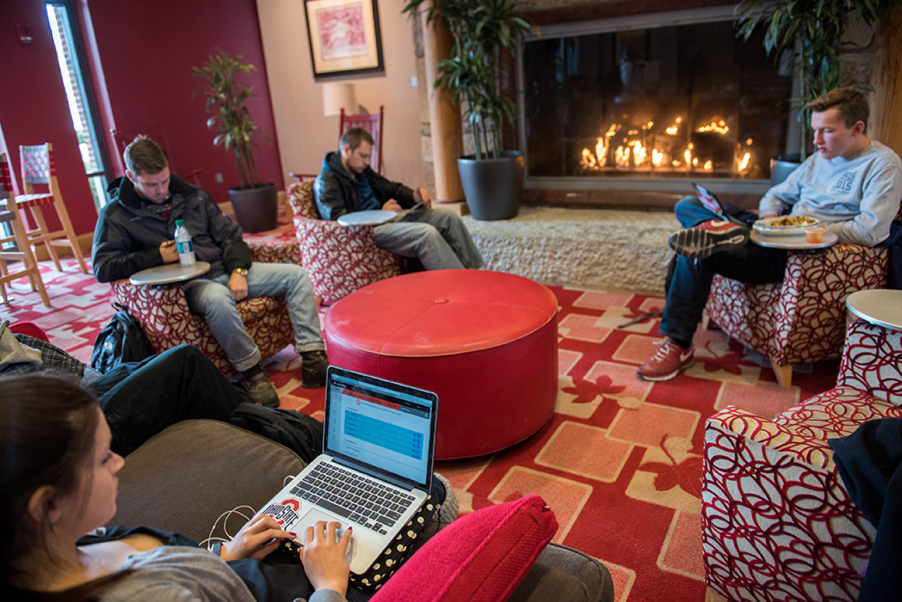 Buckeyes studying in front of a lit fireplace with laptops in a circle. Image courtesy of The Ohio State University.