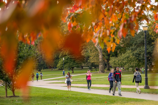 Students walking to class as trees change color on the Oval, The Ohio State University. Image courtesy of The Ohio State University