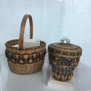 Three baskets made of splints from the Black Ash tree. Some strips are colored a deep brown and a soft black. 