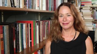 Dr. Jean O'Brien (White Earth Ojibwe Nation) in front of a a bookcase filled with books. University of Minnesota.