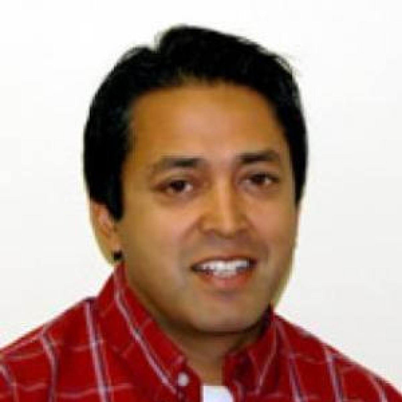 Assistand Dean and Associate Professor of Education, Dr. Binaya Subedi in a red checked dress shirt.