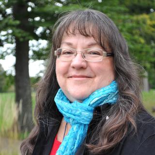 Marti Chaatsmith wearing a blue scarf. Image courtesy of Marti Chaatsmith.