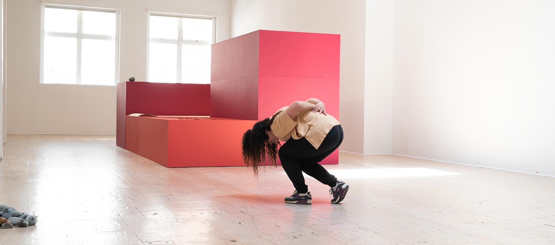 Woman bowing in the middle of partially empty room
